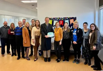 Community members pose with celebration cake for Cranford YMCA's First Anniversary.