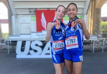 Two Flyer Track Club members with their medals