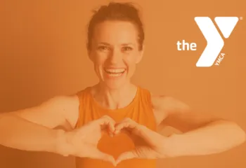 Woman in workout clothes holing up a heart sign with her hands