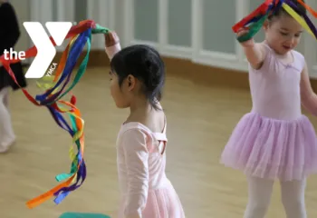 Toddlers in a dance studio wave colorful ribbon props during a YMCA dance class.