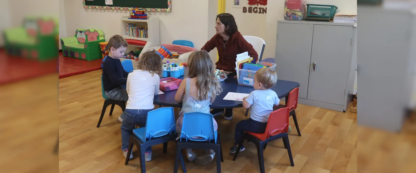 Group coloring activity with a Kids Club teacher