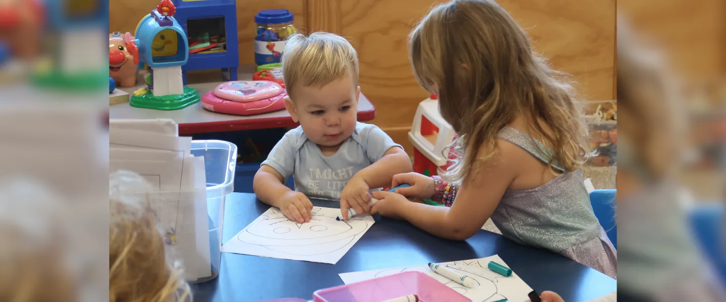 Brother and sister coloring together.