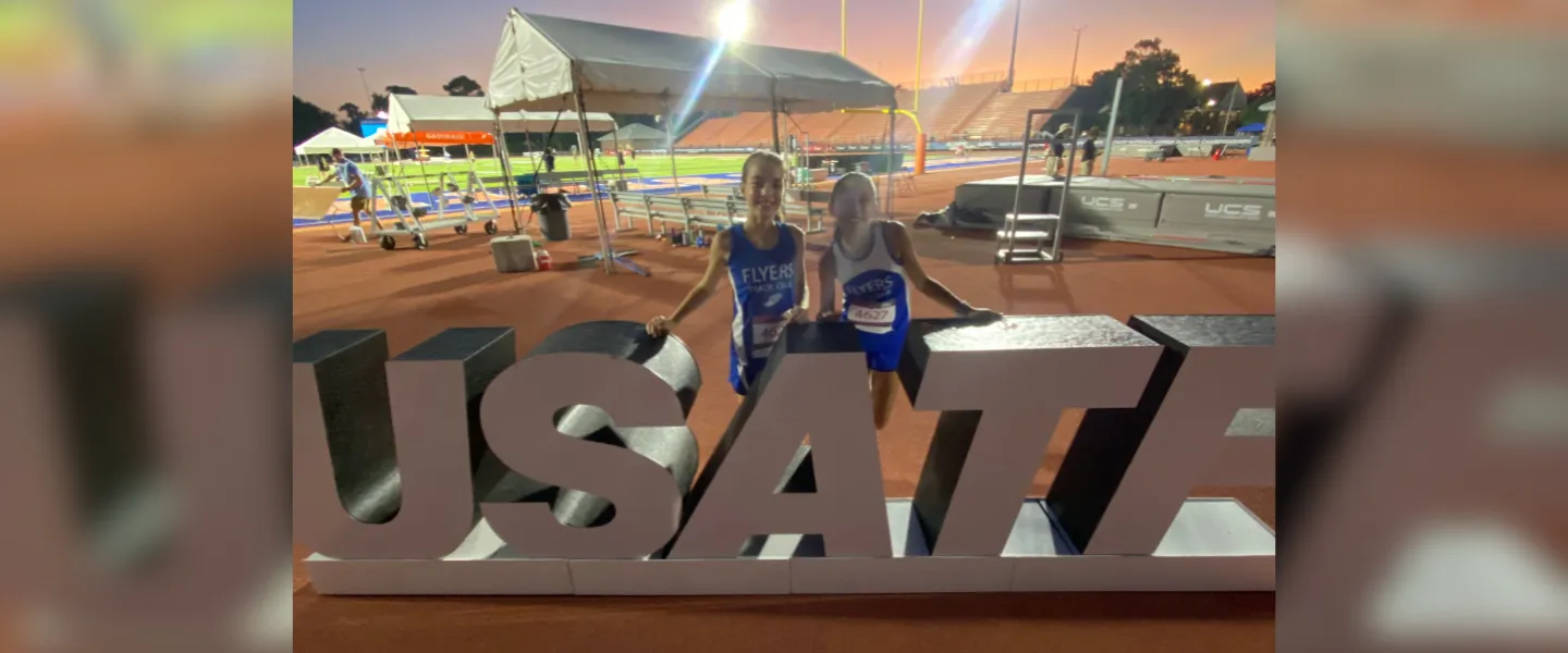 Two Flyers athletes with USATF sign