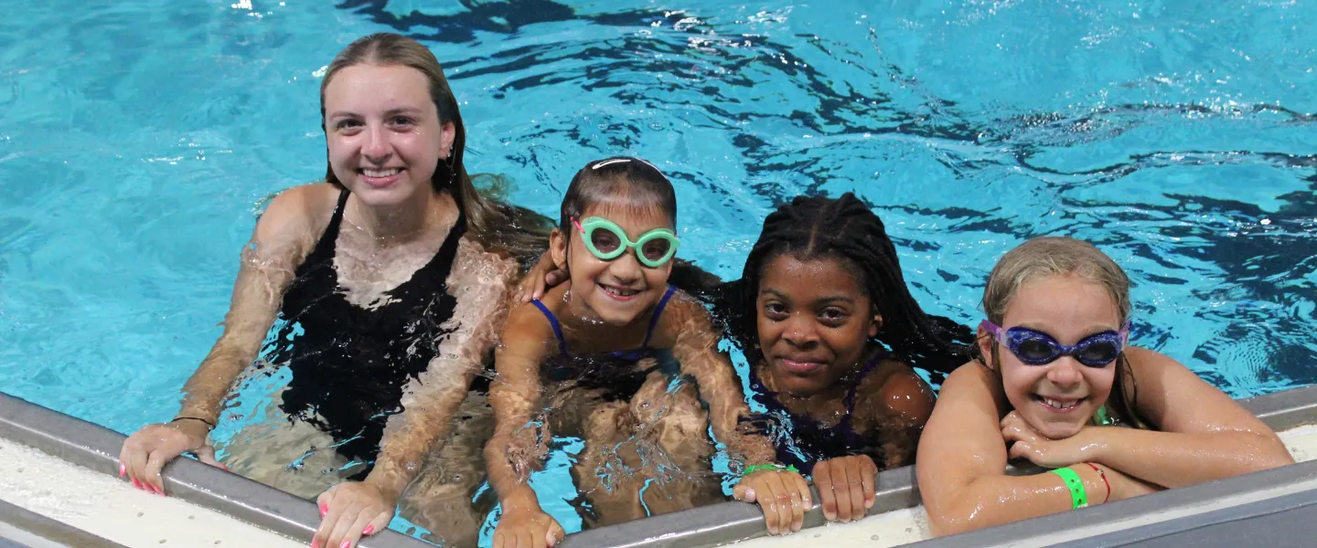 3 campers with counselor in the pool