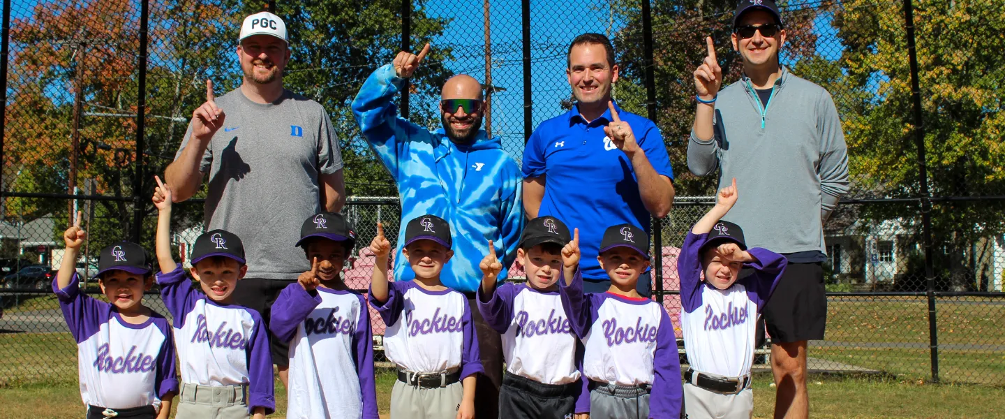 Rockies T-Ball Team holding up the number 1 with their four coaches.