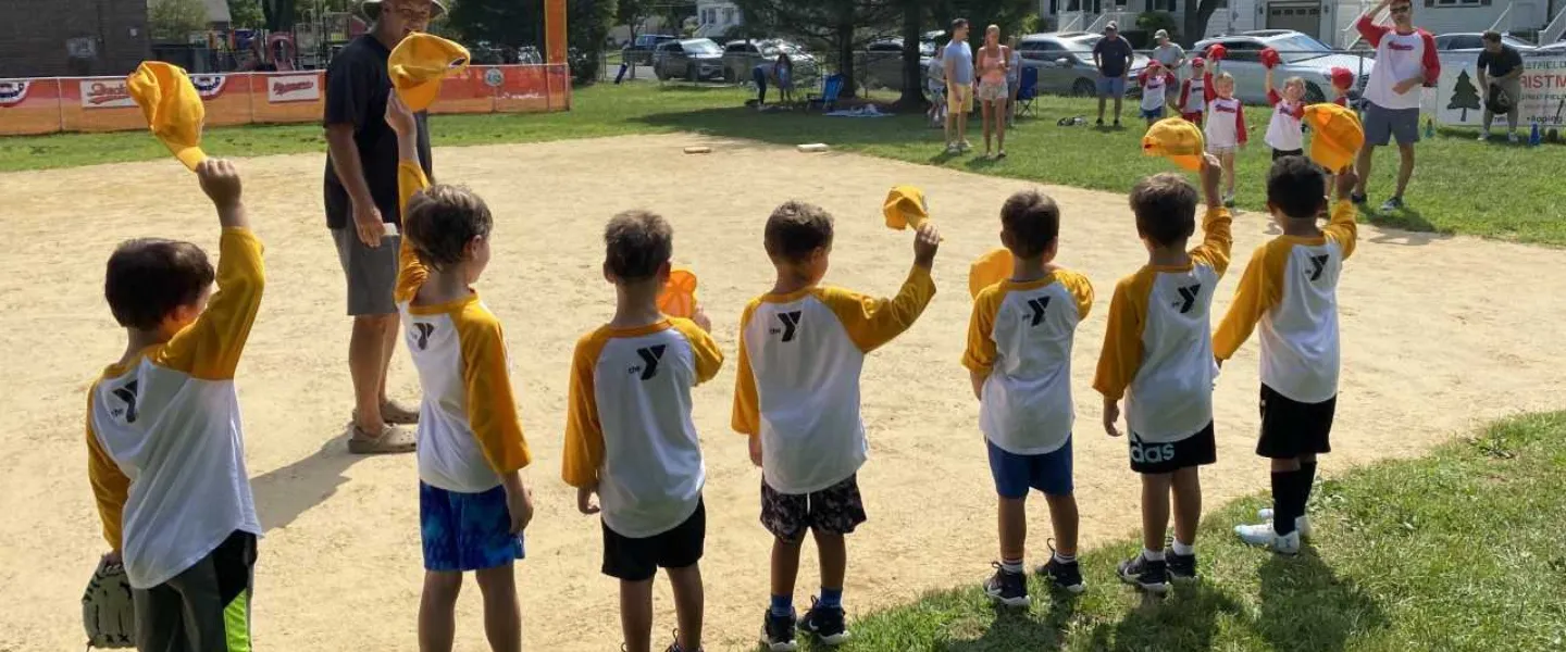 T-Ball team waving their hats.