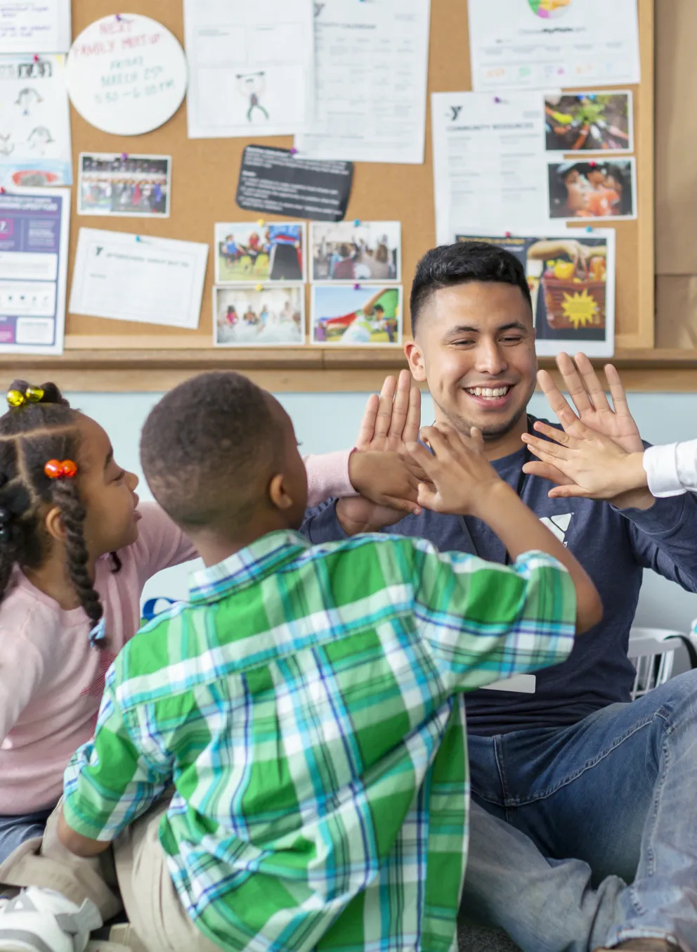 YMCA Staff member high-fiving school children in after care