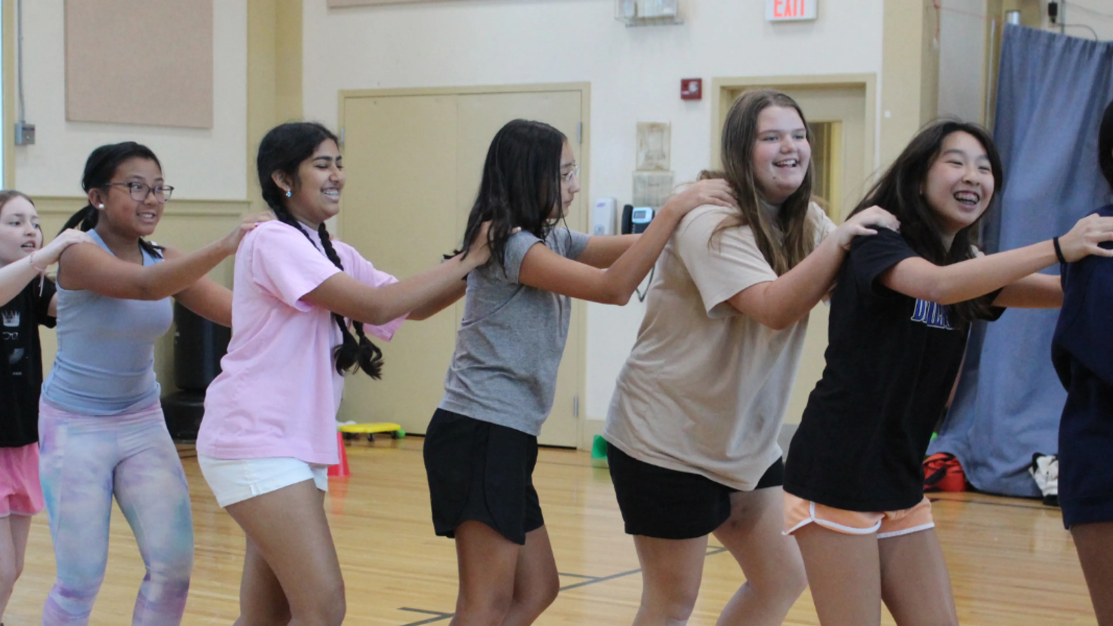 Teens dancing in a conga line at the Bauer Branch