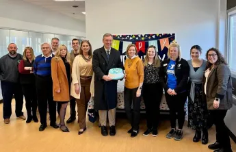 Community members pose with celebration cake for Cranford YMCA's First Anniversary.