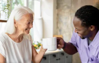 Elderly woman having coffee with a volunteer