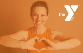 Woman in workout clothes holing up a heart sign with her hands