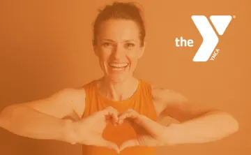 Woman in workout clothes holing up a heart sign with her hands