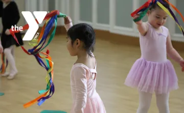 Toddlers in a dance studio wave colorful ribbon props during a YMCA dance class.